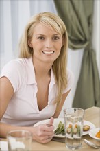 Portrait of woman at dinner table.