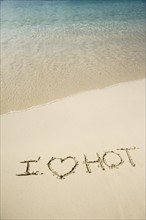 I Love Hot written in sand.