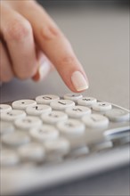 Close up of woman using calculator.