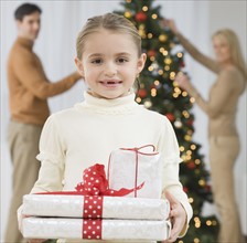 Portrait of girl holding gifts on Christmas.