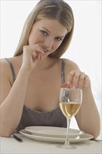 Portrait of woman at table with glass of wine.