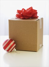Shipping box with gift bow and Christmas ornament.