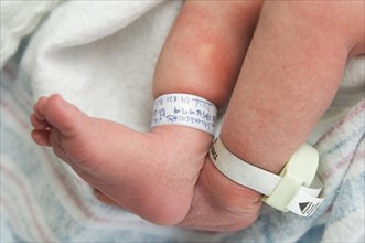 Newborn baby's feet with hospital tags.