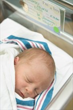 Newborn baby in hospital bed.
