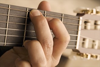 Close up of man's hand playing guitar.