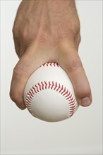Close up of pitcher holding baseball.