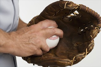 Close up of man with baseball glove and baseball.