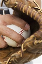 Close up of man with baseball glove and baseball.