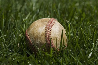 Close up of baseball in grass.