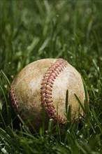 Close up of baseball in grass.