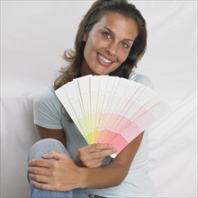 Woman smiling and holding paint swatches.