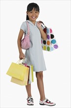 Studio shot of girl carrying shopping bags.