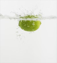 Citrus fruit dropped into water.
