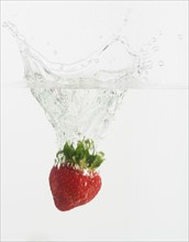 Strawberry dropped into water.