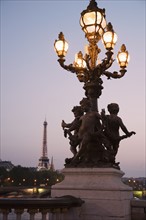 Lamp post with cherubs with Eiffel Tower in background.