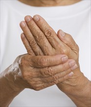 Close up of senior rubbing hands together.