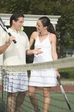 Couple talking on tennis court.