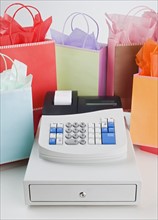 Cash register surrounded by gift bags.