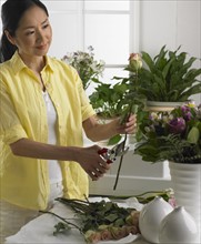 Woman cutting and arranging flowers.