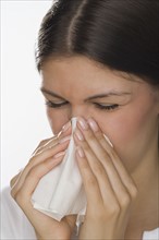 Close up of woman blowing nose.