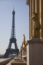 Golden statues with Eiffel Tower in background.