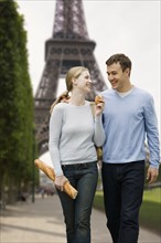 Couple walking with Eiffel Tower in background.