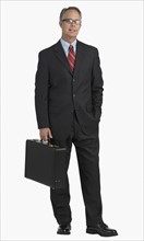 Studio shot of businessman holding briefcase.