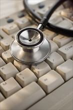 Close up of stethoscope on computer keyboard.