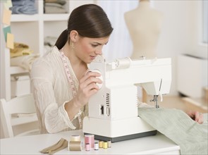 Woman using sewing machine.