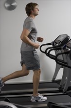 Man running on treadmill at health club.