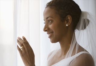 Bride looking out window.