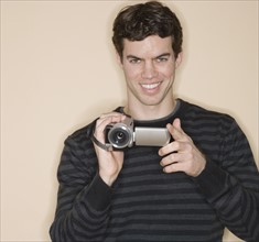 Portrait of man holding video camera.