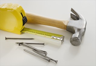 Close up of hammer, nails and tape measure.
