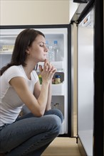 Woman looking in refrigerator.