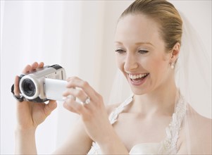 Bride using video camera.