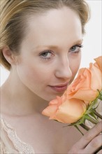 Close up of woman smelling flowers.