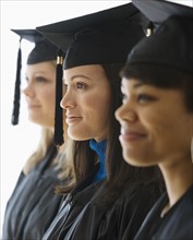 Multi-ethnic women wearing graduation cap and gown.