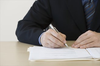 Businessman writing in folder.