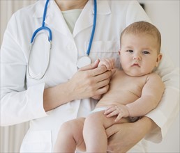 Female doctor holding baby.