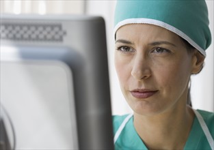 Female doctor looking at computer.