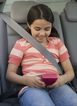 Girl playing video game in car.