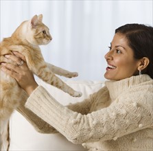 Indian woman holding cat.