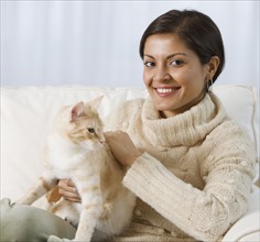 Indian woman petting cat.