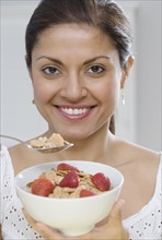 Indian woman eating cereal.