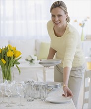 Woman setting table.
