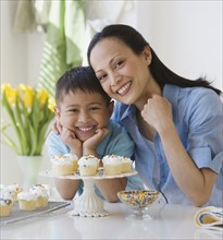 Asian mother and son with cupcakes.