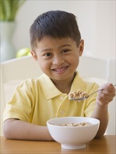 Asian boy eating cereal.