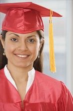 Indian woman wearing graduation cap and gown.