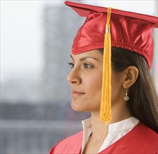 Indian woman wearing graduation cap and gown.