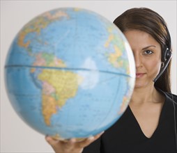 Indian businesswoman holding globe.